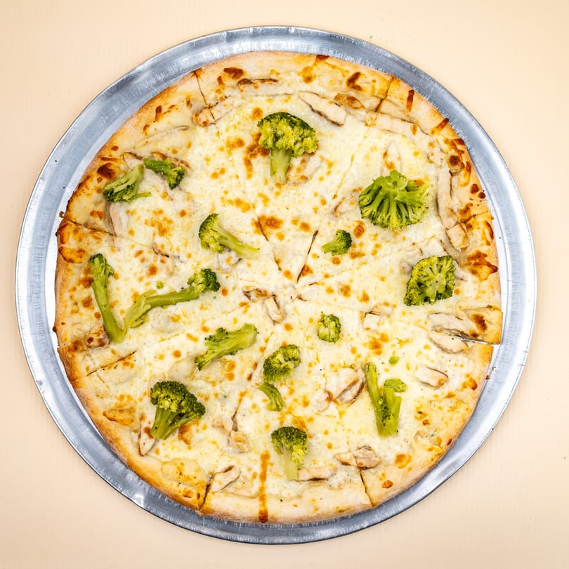 All Star Pizza's white pizza with chicken and broccoli, served on a metal pan.